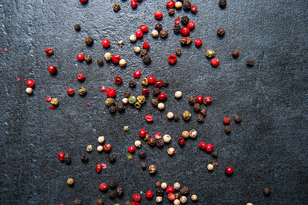 istock Black, white and red pepper on dark stone 583692602