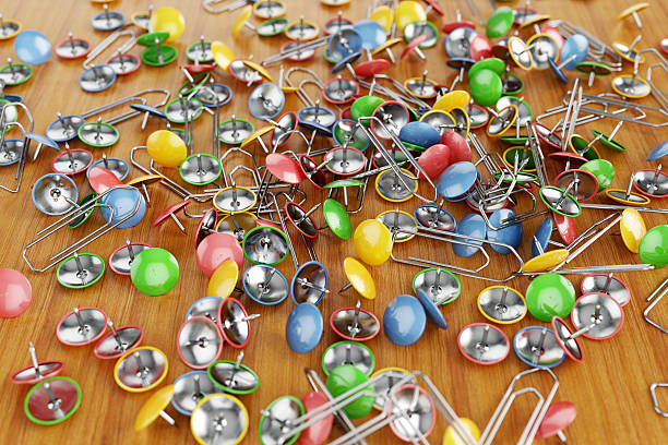 istock Paper clips and drawing pins scattered on a table. 583695004