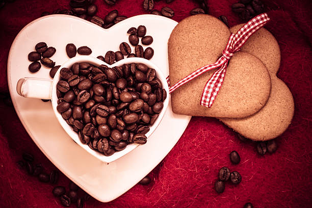 istock Coffee beans in heart shaped cup and dessert on red 583695564
