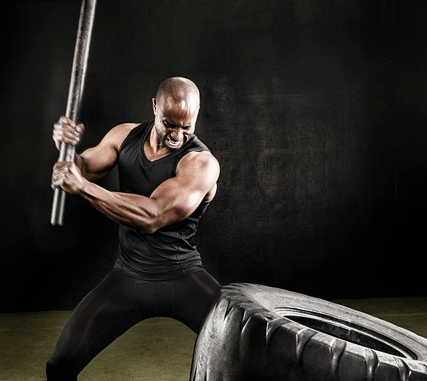istock Athlete swinging pipe against tire for workout. 583696610