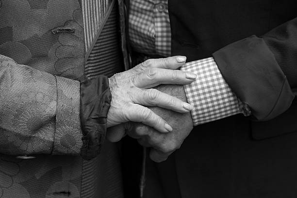 istock Hands. Elderly man and an elderly woman holding hands. Black and white. 583698448