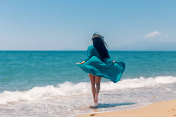 istock Young woman running on the beach 583699948