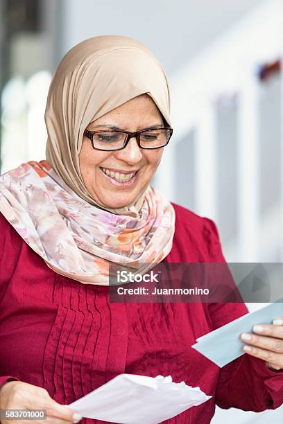 Middle Eastern Woman Cheking The Mail Stock Photo - Download Image Now - Checking - Sports, Examining, Mail