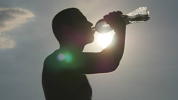 istock Young man drinking water from a plastic bottle in nature 583701598