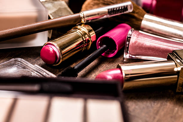 istock Pile of various cosmetics, make-up lie on wooden dressing table. 583707238