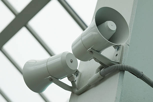 Pair of megaphones on the wall of the building. A pair of megaphones on the wall of the building. public address system stock pictures, royalty-free photos & images