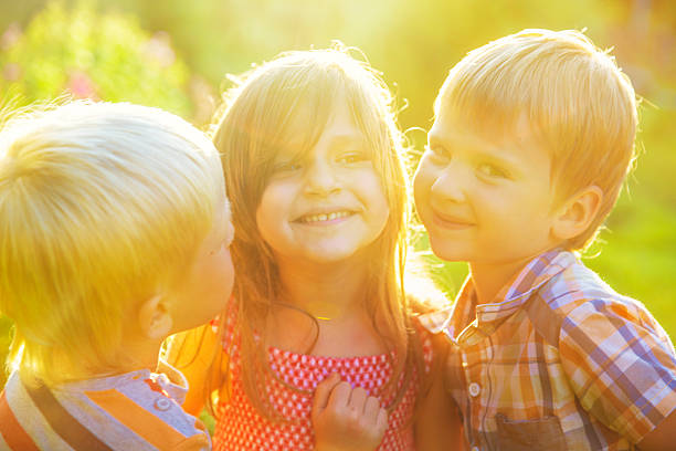 istock Two boys hugging a girl on outdoors 583707614