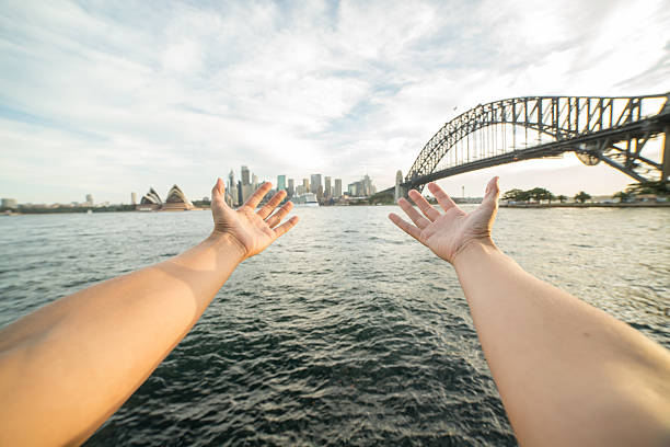 istock Woman's arms stretch towards Sydney skyline, Australia 583710394