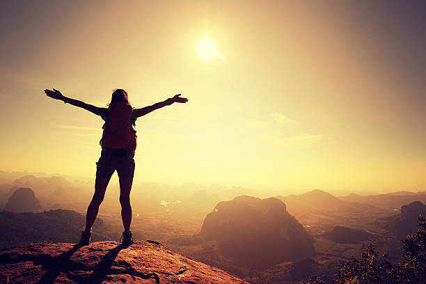 istock cheering woman hiker at sunrise mountain peak 583710430