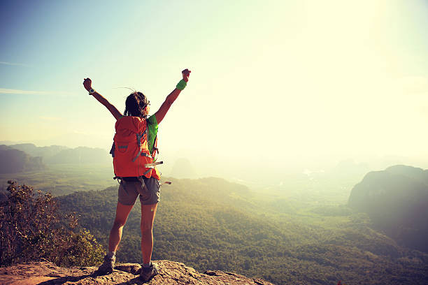 istock cheering woman hiker at sunrise mountain peak 583710690