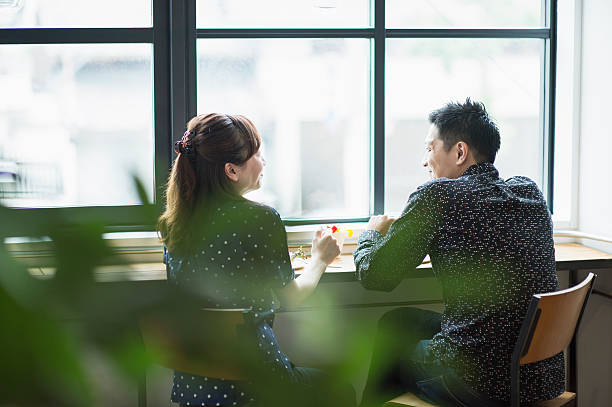 mittleres erwachsenes paar genießt das mittagessen im café. - japanisch sprache stock-fotos und bilder