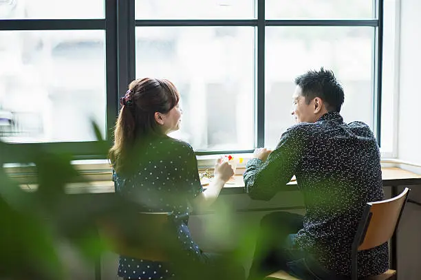 Photo of Mid adult couple enjoying Lunch in cafe.