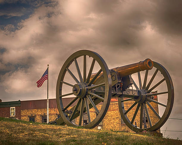 Civil War era cannon with American flag flying in the background with dramatic sky in rural Ohio