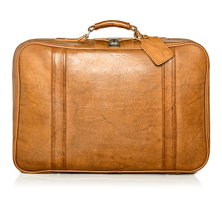 A vintage leather suitcase with a tag. 