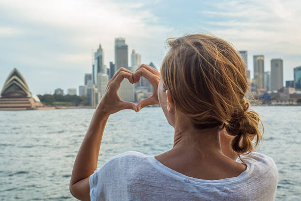 istock Woman framing Sydney skyline into heart shape finger frame 583718250