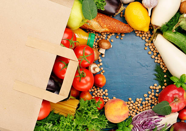 istock Paper bag with food on blue surface with copy space 583719168