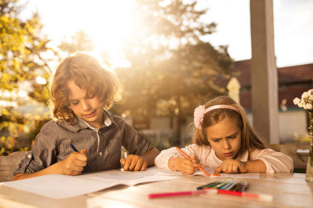 istock Creative brother and sister sketching in the backyard. 583720602