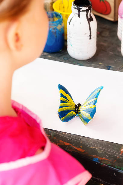 istock Girl paints a butterfly 583721068
