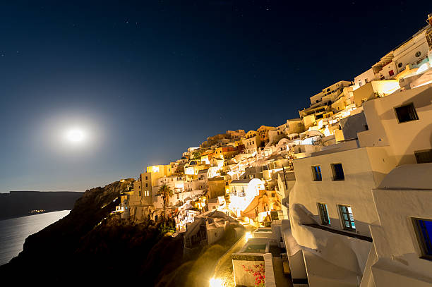 Houses near the cliff lit by moonlight stock photo