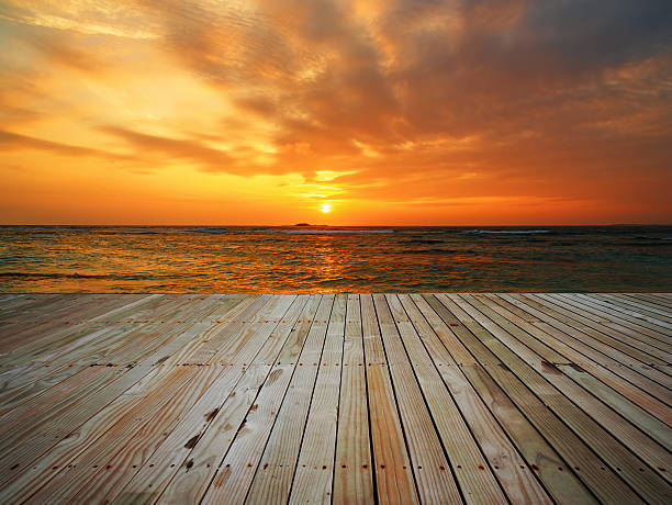 istock Wooden platform beside sea on sunrise 583724568