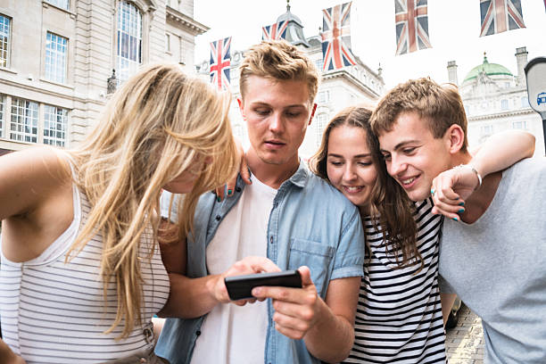 istock friends watching the smartphone in piccadilly circus 583724770