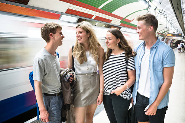 istock friends talking and waiting the train on a subway station 583725110