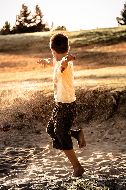 istock Seven years bare foot boy playing with sand 583725260