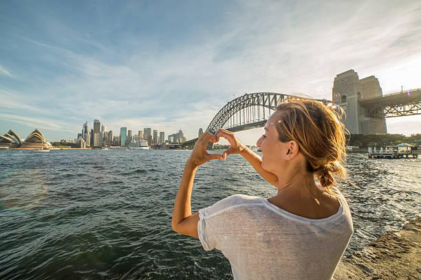 istock Caucasian female makes heart shape finger frame on Sydney skyline 583725586