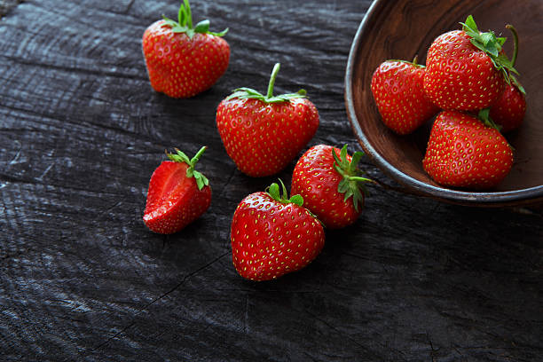 istock Red fresh strawberries on black rustic wood background 583727422