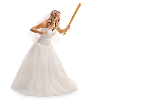 Full length portrait of an enraged bride threatening someone with baseball bat isolated on white background