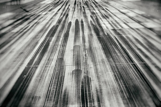 Tire tracks and marks at the end of an airfield. Manipulated black and white film retro look.