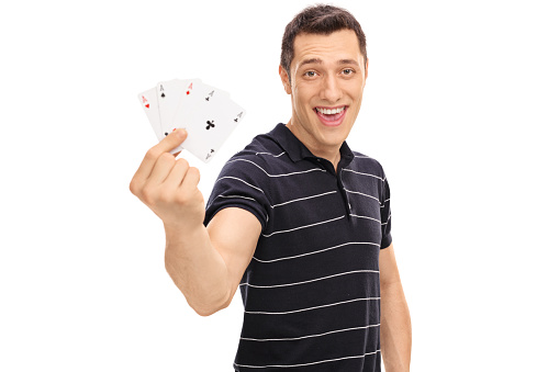 Lucky guy holding four aces and looking at the camera isolated on white background