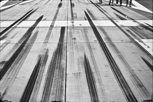 Tire tracks and marks at the end of an airfield. Manipulated black and white film retro look.
