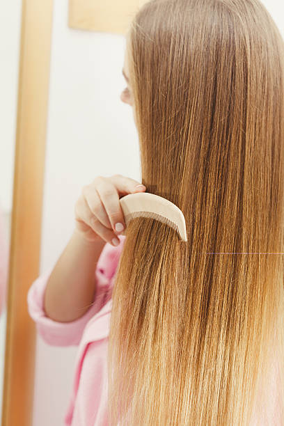 istock Woman combing her long hair in bathroom 583729690