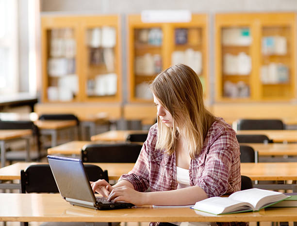 istock female student with laptop working in library 583731082