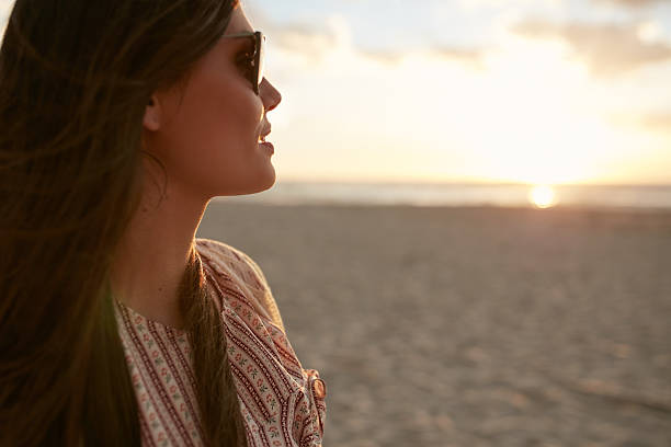 istock Attractive woman on the beach at sunset 583731184
