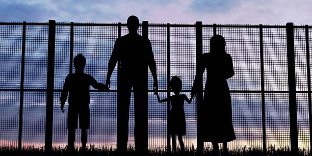 Silhouette of a refugees family with children stock photo