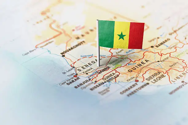 The flag of Senegal pinned on the map. Horizontal orientation. Macro photography.