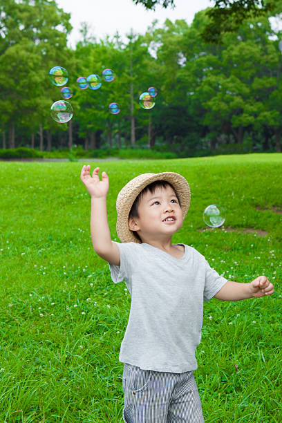istock Boy playing with soap bubbles in the park 583735062