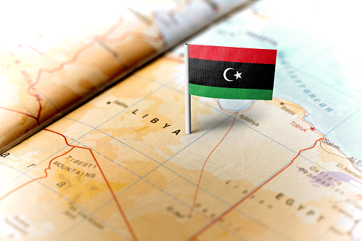 The flag of Libya pinned on the map. Horizontal orientation. Macro photography.