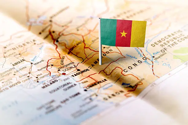 The flag of Cameroon pinned on the map. Horizontal orientation. Macro photography.