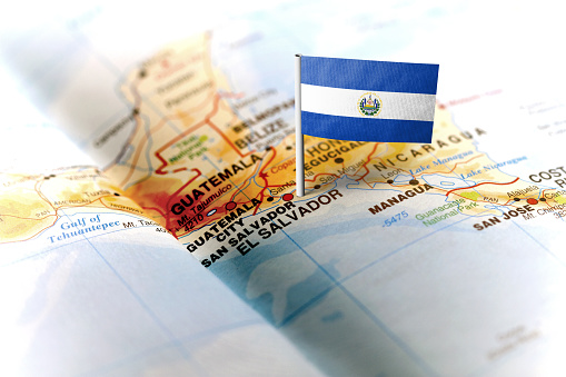 The flag of El Salvador pinned on the map. Horizontal orientation. Macro photography.
