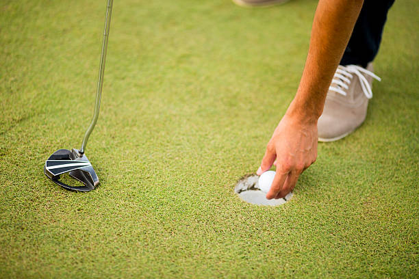 istock Golf ball, putter and boy's legs on green 583796014