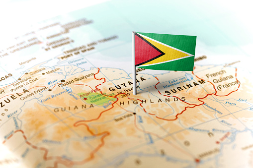 The flag of Guyana pinned on the map. Horizontal orientation. Macro photography.