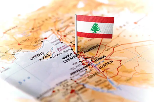 The flag of Lebanon pinned on the map. Horizontal orientation. Macro photography.