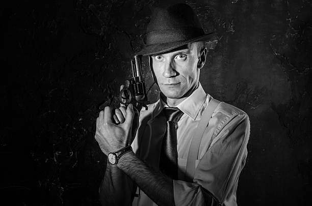 暗闇の中で銃を持っている帽子をかぶったハンサムな探偵 - fashion old fashioned old social issues ストックフォトと画像