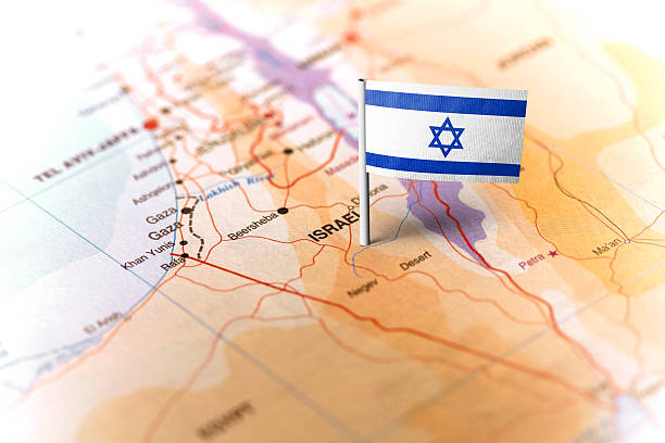 The flag of Israel pinned on the map. Horizontal orientation. Macro photography.
