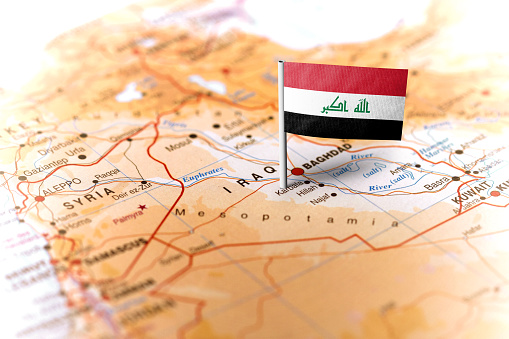 The flag of Iraq pinned on the map. Horizontal orientation. Macro photography.