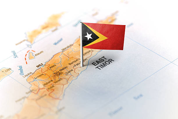 The flag of East Timor pinned on the map. Horizontal orientation. Macro photography.
