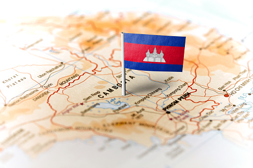 The flag of Cambodia pinned on the map. Horizontal orientation. Macro photography.